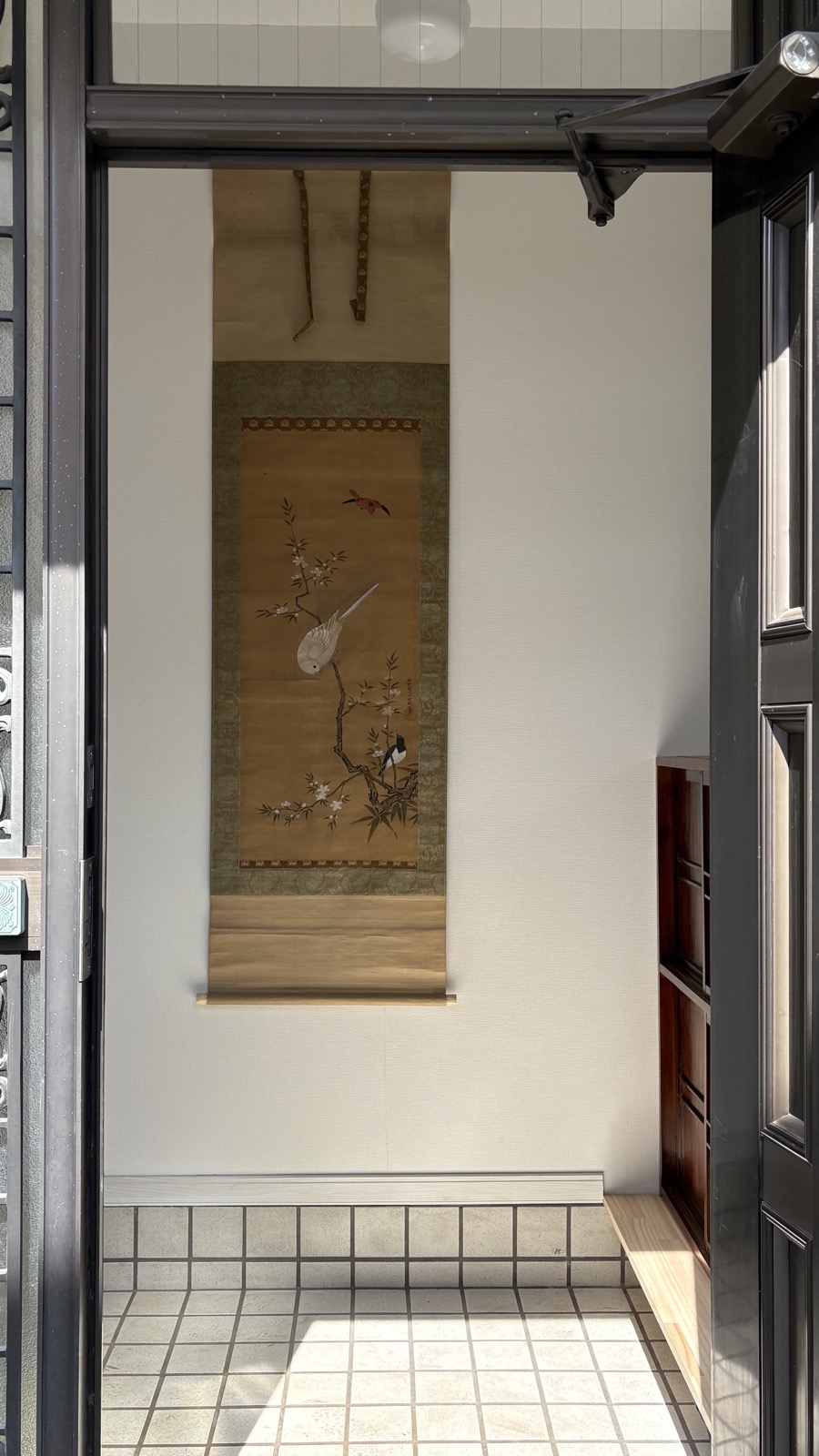 Restored akiya entrance with hanging scroll and vintage tansu