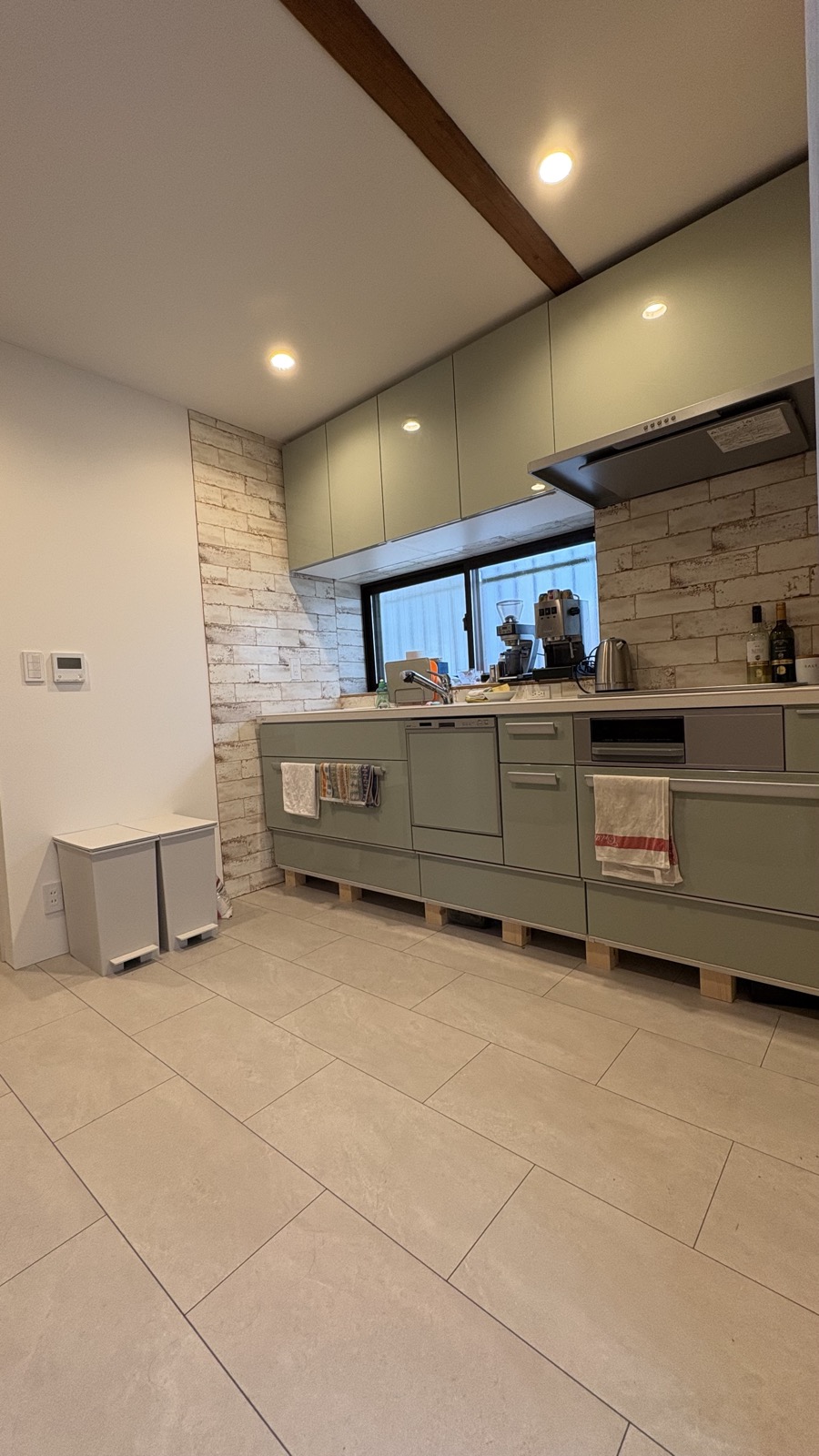 Beautifully restored kitchen with sage green cabinets and stone wall