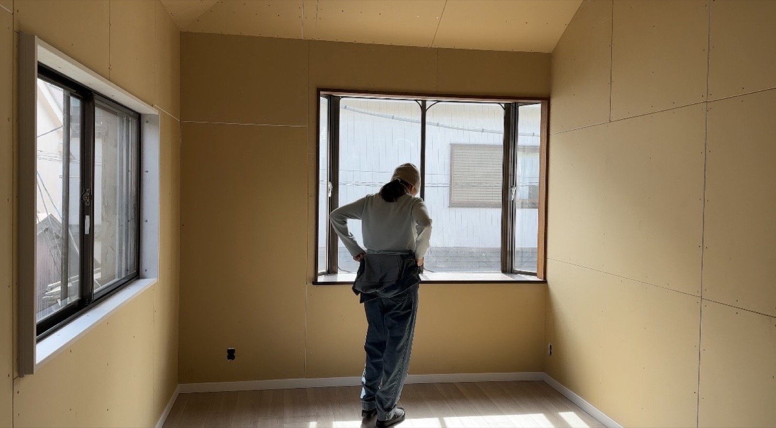 Misaki surveying progress in newly drywalled room